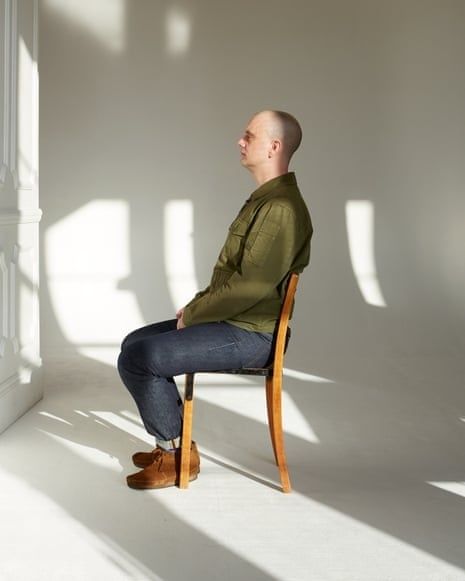 Man sitter stilla på en stol i ett ljust, tyst rum